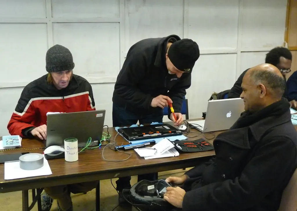 Técnicos reparando portátiles en una mesa de trabajo
